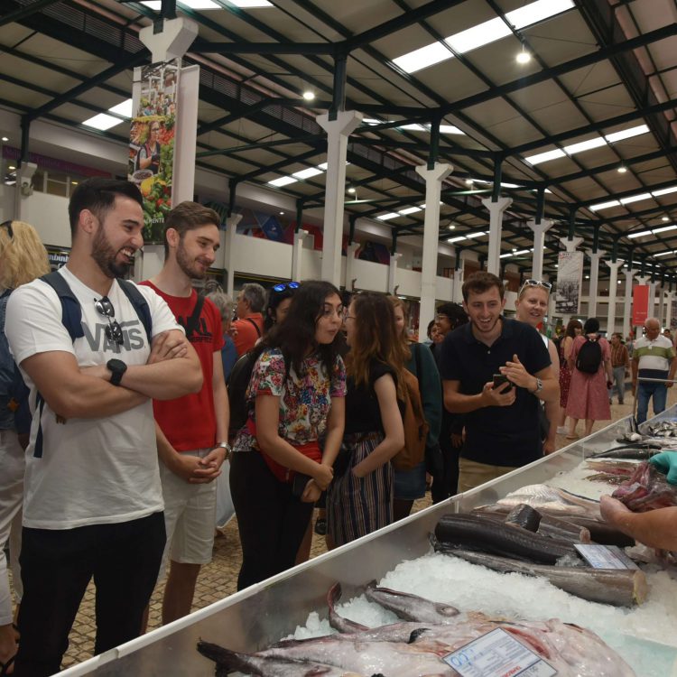 Participantes do evento escutando um vendedor de peixe no Mercado do Livramento